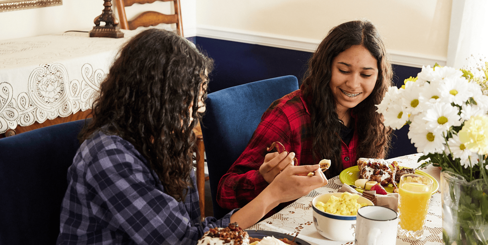Two girls sitting at table eating food